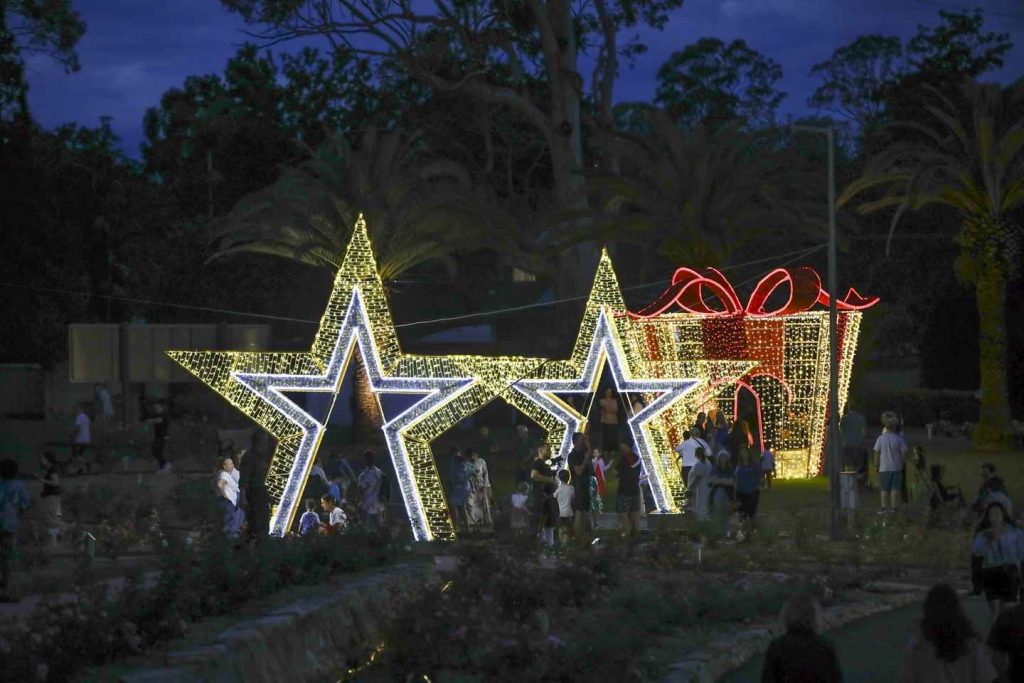 a group of people standing around a group of stars with lights at the Illuminate The Hills 2023