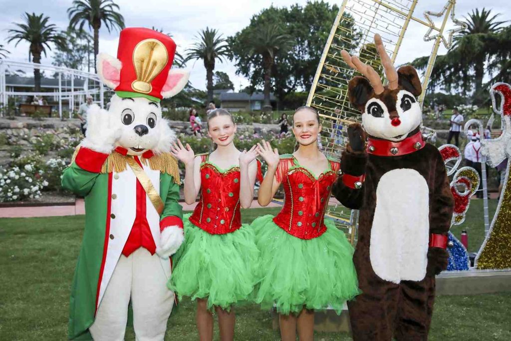 a group of people in clothing posing for a photo for the Illuminate the Hills Christmas event